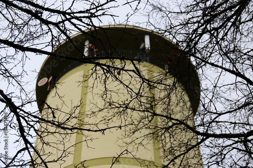 Yellow tower with creepy black tree branches 