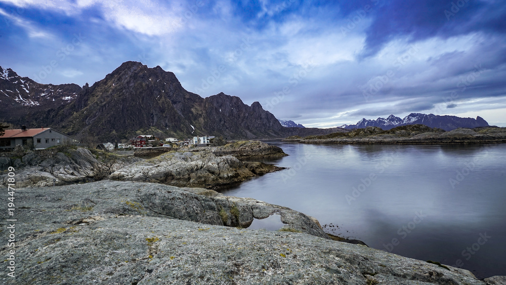 Long exposure photography of a small red hut in Svovar  with silky lake , Lofoten Isalnd, Norway