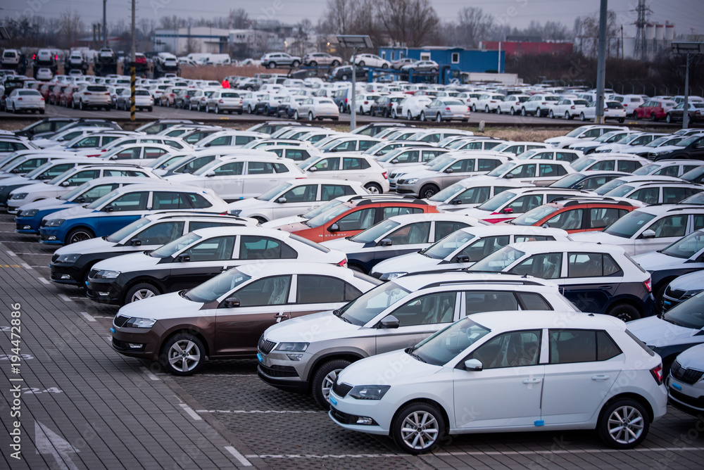 Obraz premium Brand new motor vehicles in a parking lot waiting for export