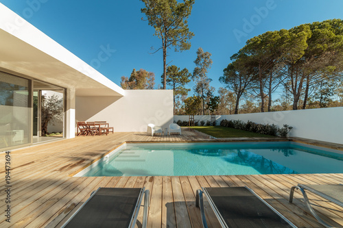 Modern house with garden swimming pool and wooden deck