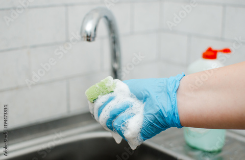 Cleaning in the apartment. Female hands in blue rubber gloves. Cleaning Concept