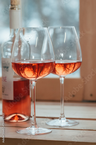 A closeup of rose wine bottle and two filled glasses