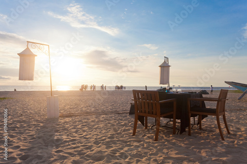 Ahungalla, Sri Lanka - A single table at Ahungalla Beach prepared for dinner for two during sundown photo