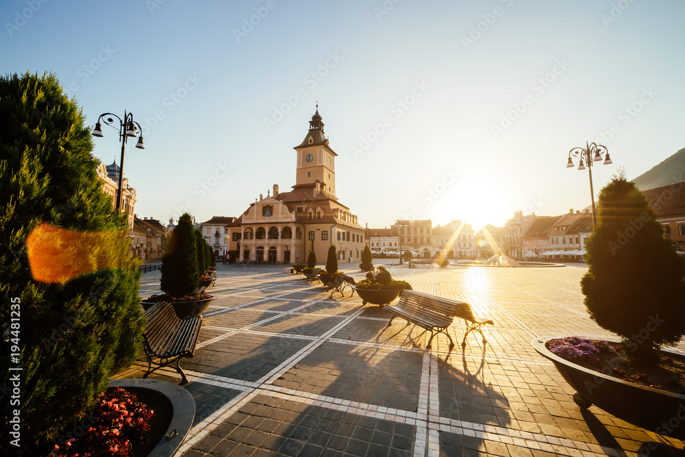 City central square (Piata Sfatului) with town council hall tower morning sunrise view, location Brasov, Transylvania, Romania. Famous travel destination summer postcard.