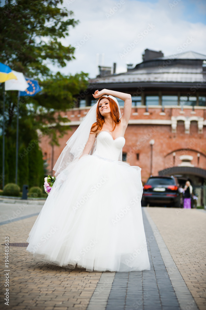 Fashion bride girl in gorgeous wedding dress with wedding bouquet of flowers