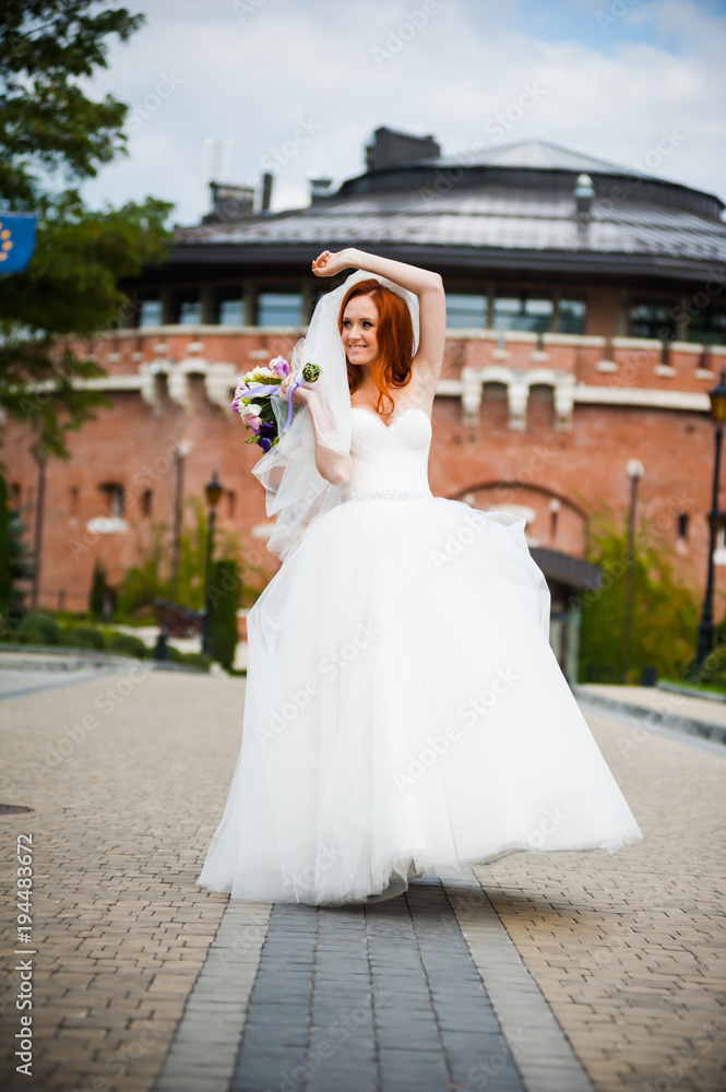 Fashion bride girl in gorgeous wedding dress with wedding bouquet of flowers