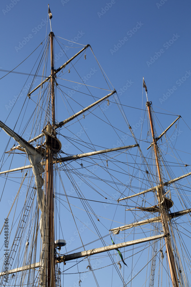 Masts and rigging of a sailing ship against blue sky Masts and rigging of a sailing ship against blue sky