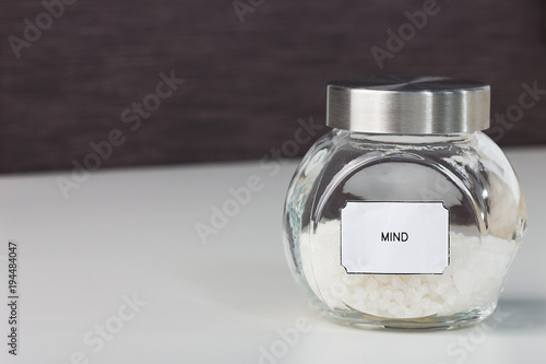 A jar of seasoning with sticker with the word mind