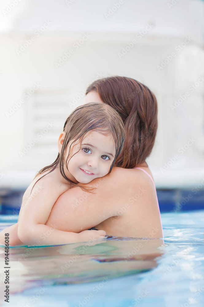Mutter umarmt ihr Kind im Schwimmbad