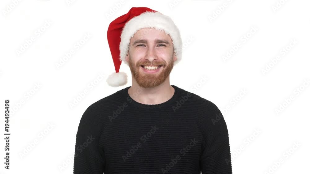 Portrait of attractive man 30s with shaved head smiling and wearing Santa Claus red hat, isolated over white background in studio. Concept of emotions Portrait of attractive man 30s with shaved head smiling and wearing Santa Claus red hat, isolated over white background in studio. Concept of emotions