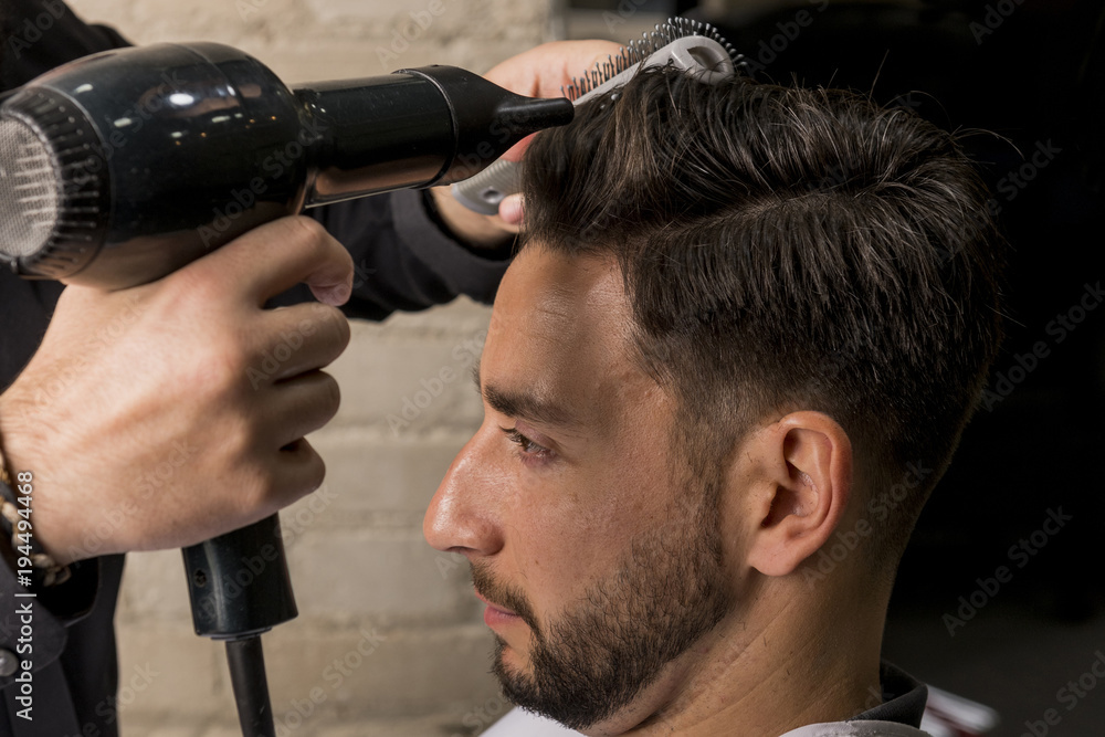 Naklejka premium Hairdresser drying a client's hair