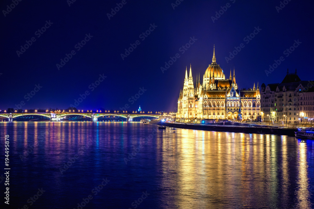 Night view of illuminated Budapest with Danube river, parliament, and bridge, Hungary.
