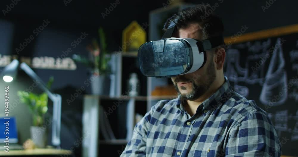 Casual man wearing VR goggles and creating virtual model working in scientific lab. Casual man wearing VR goggles and creating virtual model working in scientific lab.