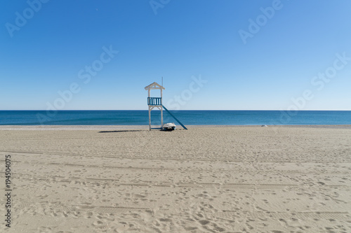 blau und weiß gestrichener Wachturm am leeren Strand 