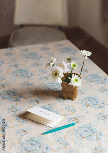 Card next to flowers on a table
