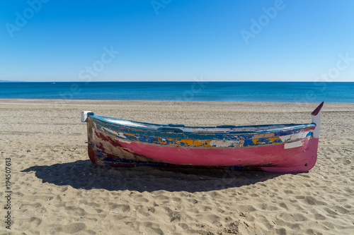 bunt gestrichenes und verwittertes Ruderboot am Strand