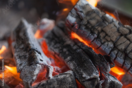 Fire with charcoals. Burning wood. Macro. Live flames with smoke. Wood with flame for barbecue and cooking bbq. Bright color. Orange