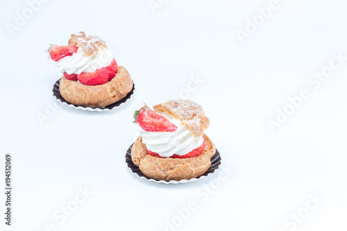 Chou aux fraises - Tart with strawberries and whipped cream. Side view on white background