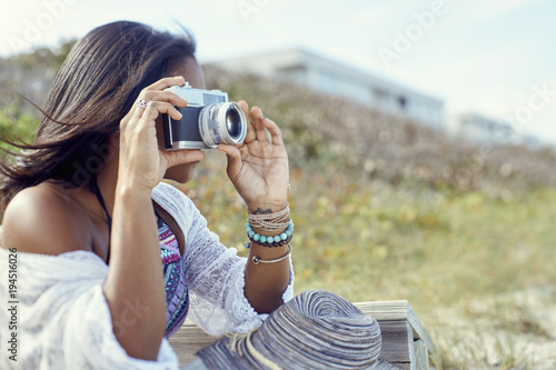 millennial woman takes photos at the beach