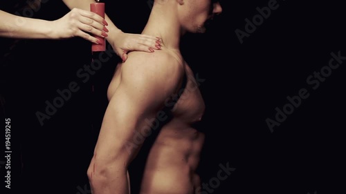 Dripping wax on a male body