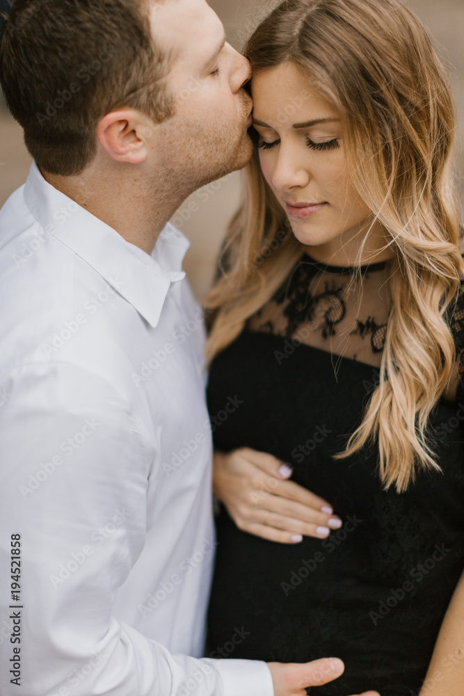 Husband kissing his pregnant wife on the forehead. Husband kissing his pregnant wife on the forehead.