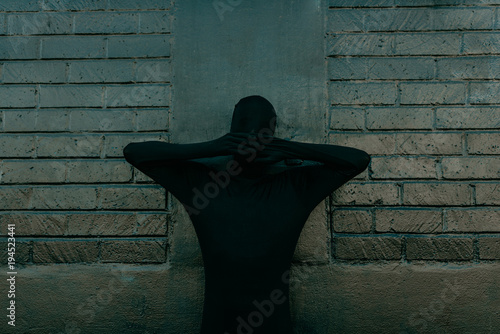 Invisible Shadow costume disguised on black wall