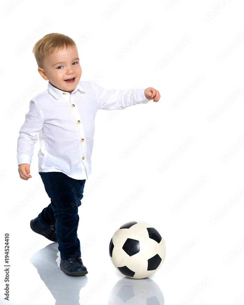 Little boy is playing with a soccer ball.