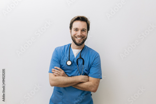 Portrait of smiling doctor standing against white background photo
