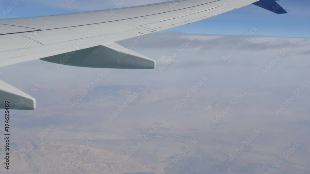 Stormy black clouds float across sky against the background of the wing of the airplane Stormy black clouds float across sky against the background of the wing of the airplane