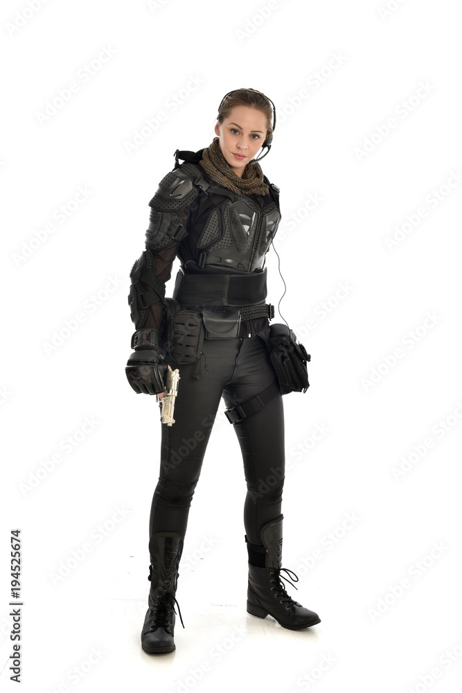 full length portrait of female soldier wearing black tactical armour, holding a remote knife, isolated on white studio background. full length portrait of female soldier wearing black tactical armour, holding a remote knife, isolated on white studio background.