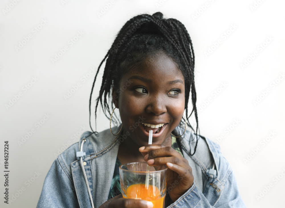 Young woman drinking cold pressed juice against simple backgroun Young woman drinking cold pressed juice against simple backgroun