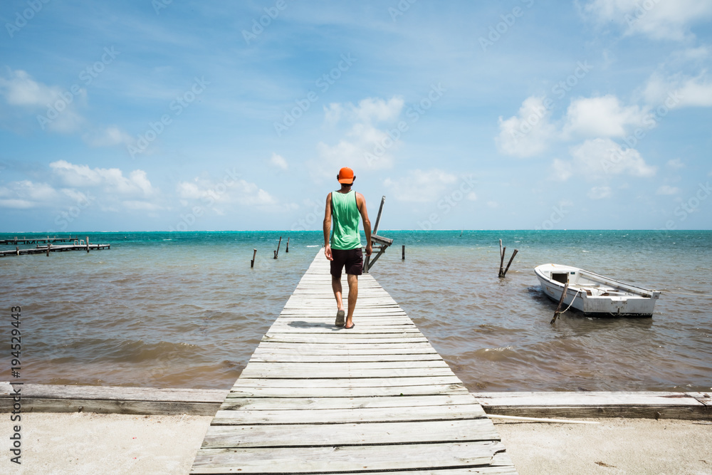 Young Man Walks on an Old Wooden Dock Young Man Walks on an Old Wooden Dock