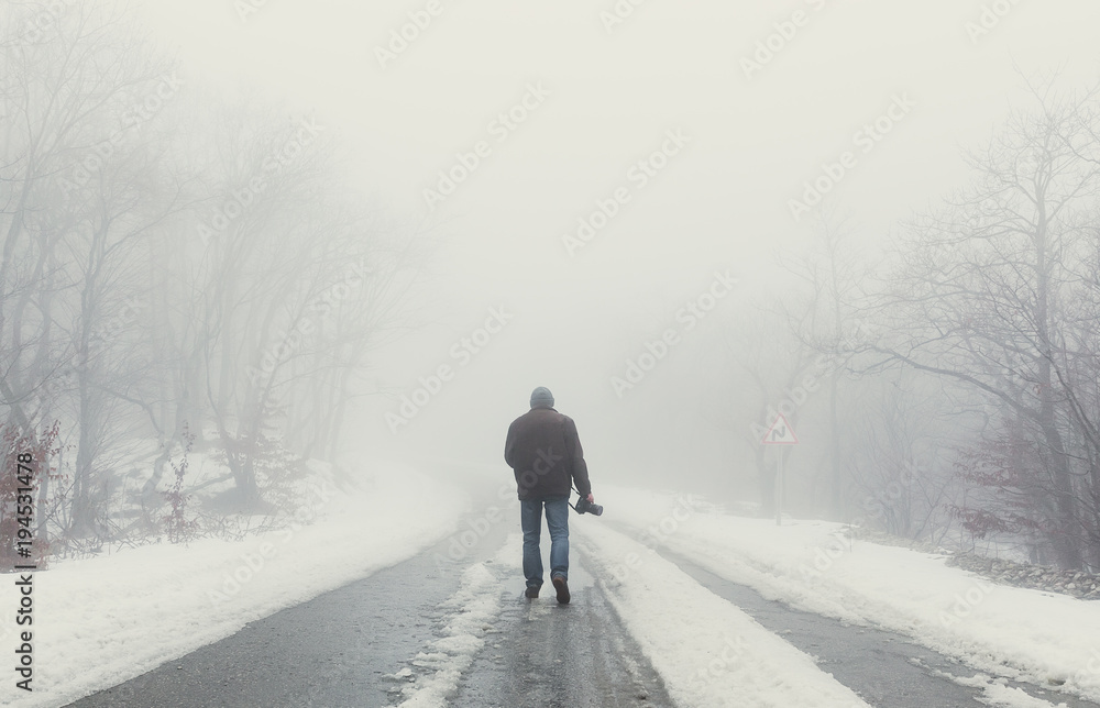 Nature photographer on foggy road