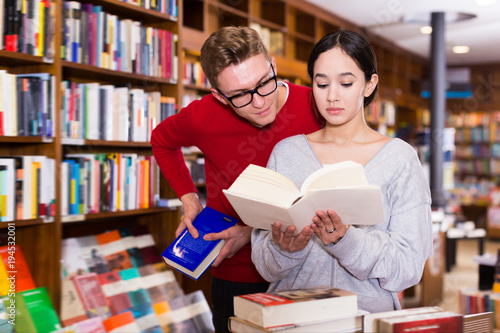 Positive student choosing book in library