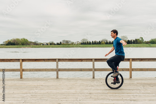 Unicyclist riding on a dock