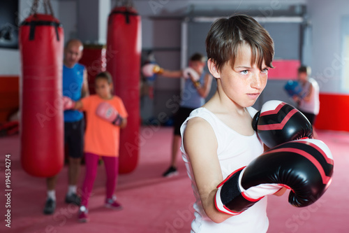 Teenage boxer in gloves posing during boxing © JackF