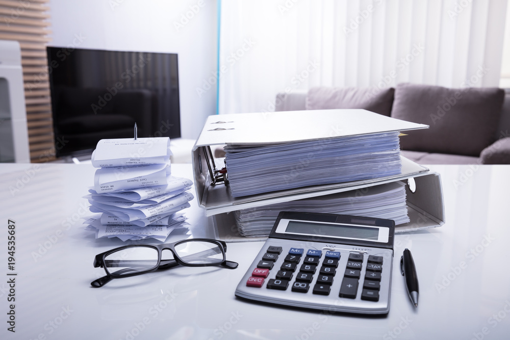 Close-up Of Folders With Receipts And Calculator