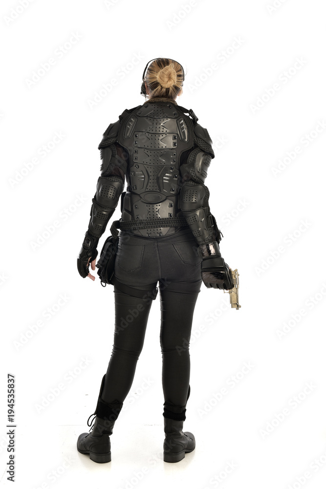 full length portrait of female  soldier wearing black  tactical armour, holding a gun, isolated on white studio background.