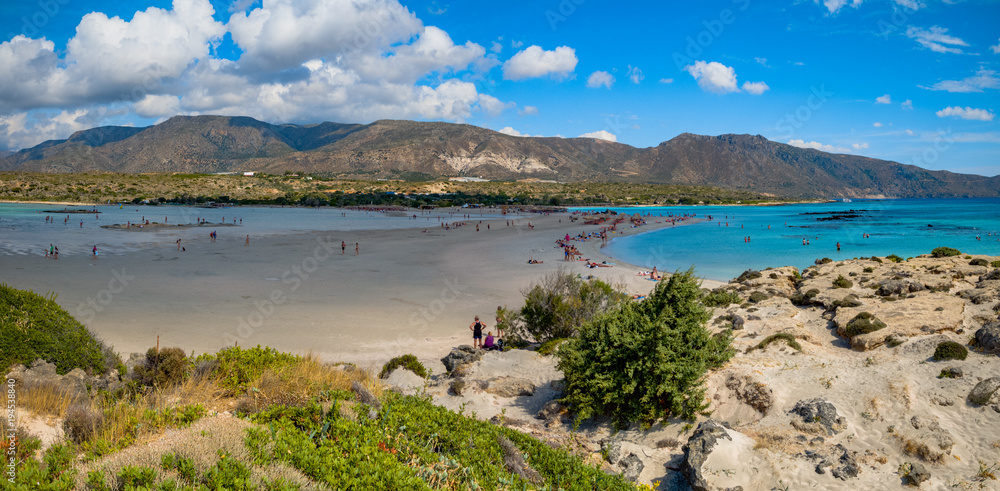 people sunbathing on the beach. beautiful views of sea, beach and mountains. Elafonisi, Crete, Greece