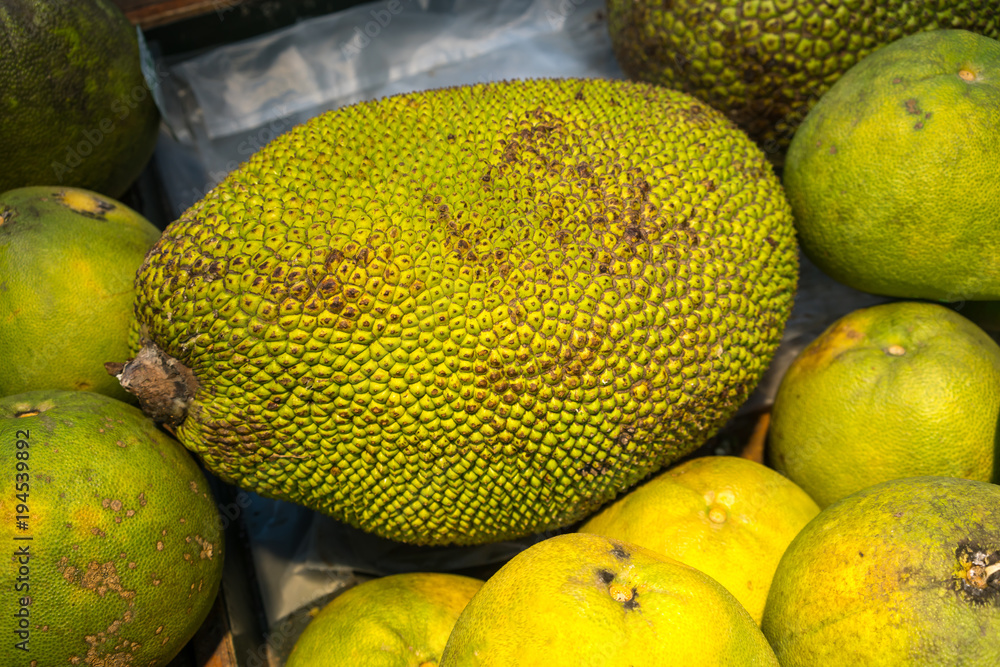 Jackfruit with green spiky skin and big stem in wooden box Jackfruit with green spiky skin and big stem in wooden box
