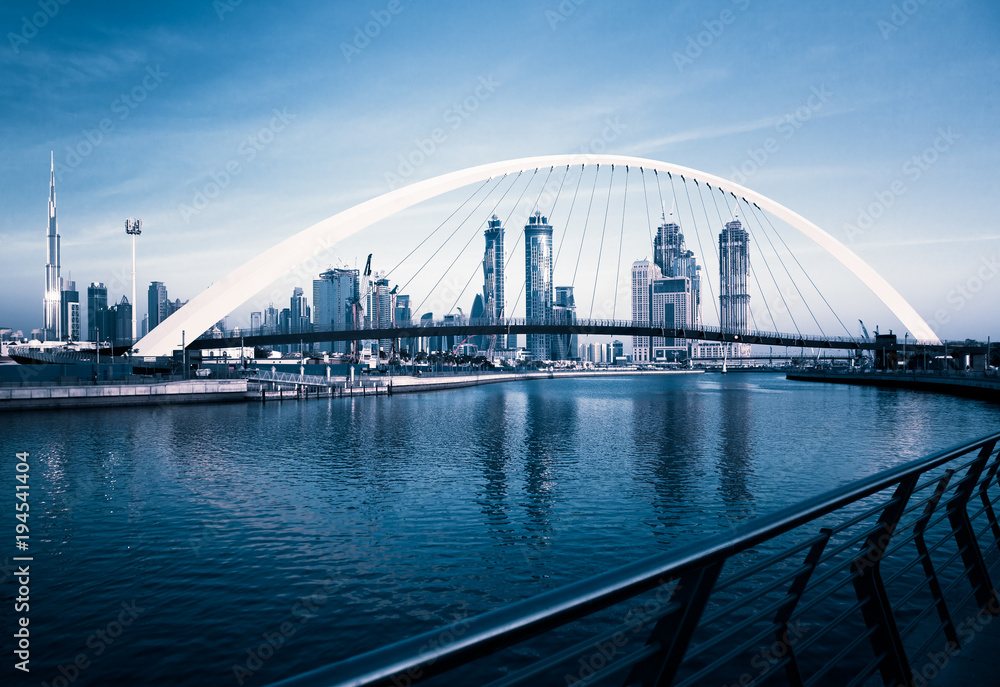 Obraz premium Dubaj, Zjednoczone Emiraty Arabskie - luty 2018: Kolorowy zachód słońca nad drapaczami chmur w centrum Dubaju i nowo wybudowanym mostem tolerancji, patrząc z kanału wodnego w Dubaju.