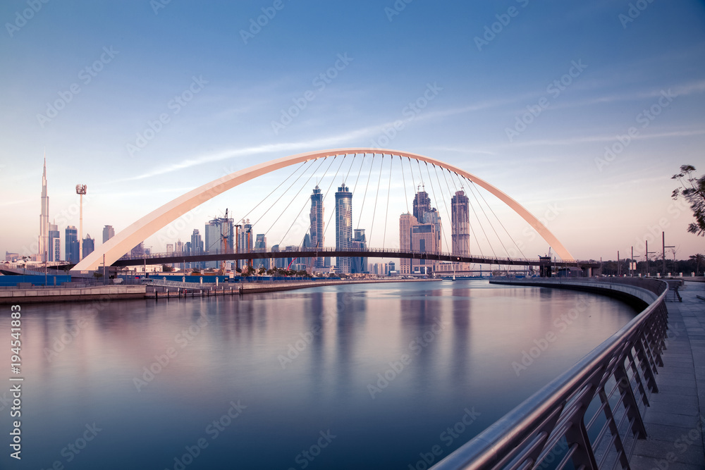 DUBAI, UAE - FEBRUARY 2018: Colorful sunset over Dubai Downtown skyscrapers and the newly built Tolerance bridge as viewed from the Dubai water canal.