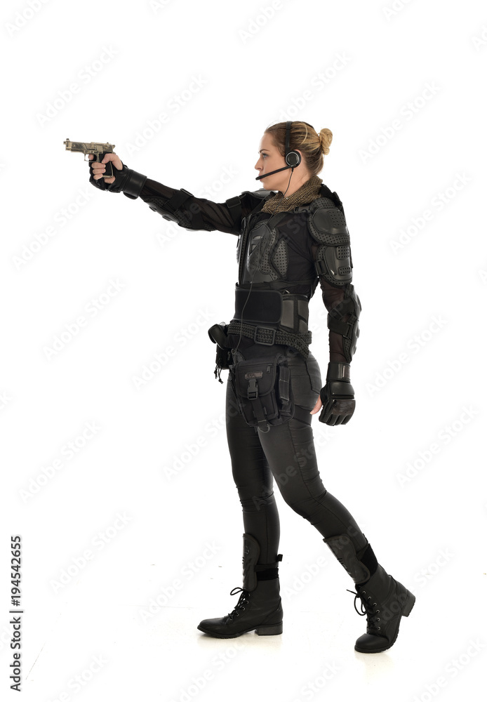 full length portrait of female soldier wearing black tactical armour, holding a gun, isolated on white studio background. full length portrait of female soldier wearing black tactical armour, holding a gun, isolated on white studio background.