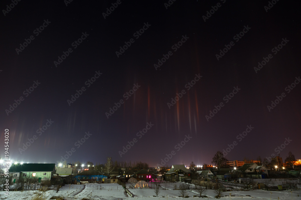 Radiance in the atmosphere. A natural phenomenon in the night sky over the illuminated residential area of the city.