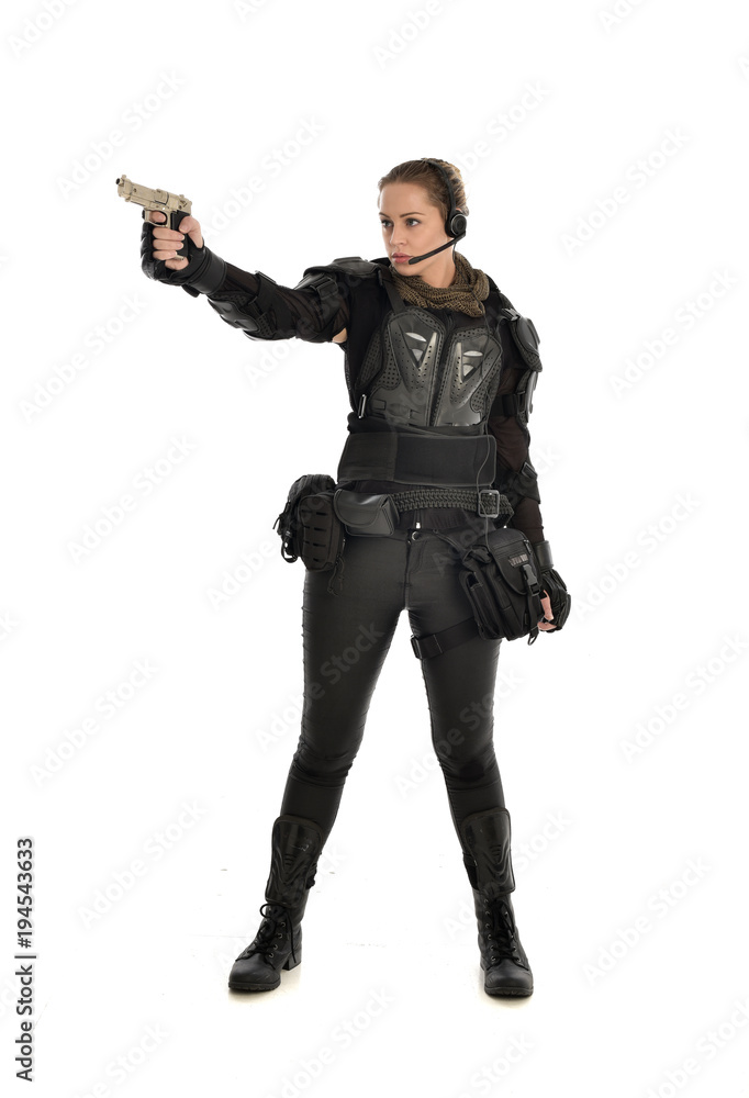 full length portrait of female soldier wearing black tactical armour, holding a gun, isolated on white studio background. full length portrait of female soldier wearing black tactical armour, holding a gun, isolated on white studio background.