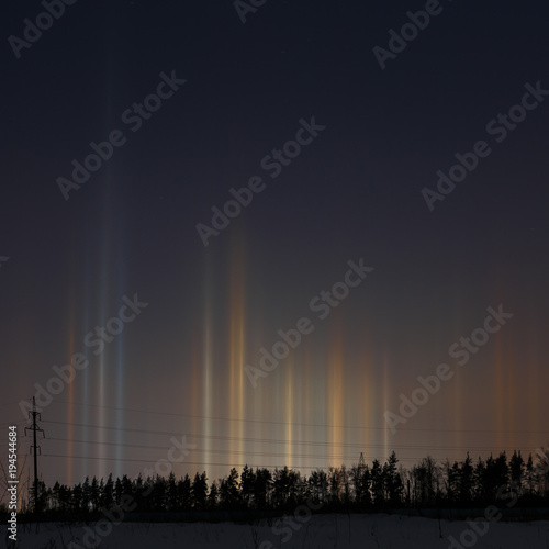 Multicolored radiance in the atmosphere. A natural phenomenon in the night sky over the forest.