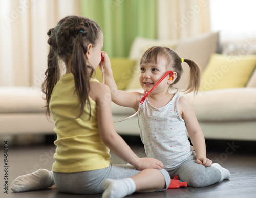 Two kids girls playing doct...