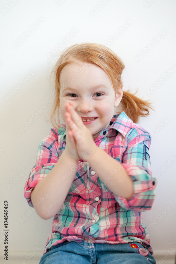 The girl claps her hands on the white background The girl claps her hands on the white background