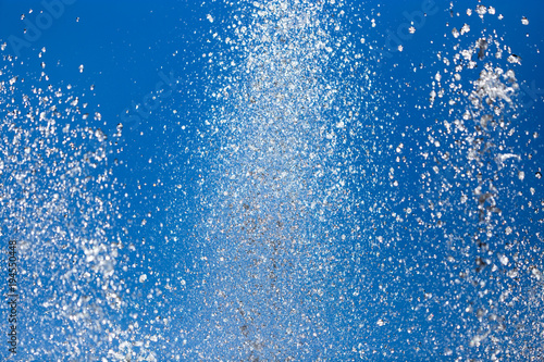 Splashing water from a fountain against the blue sky
