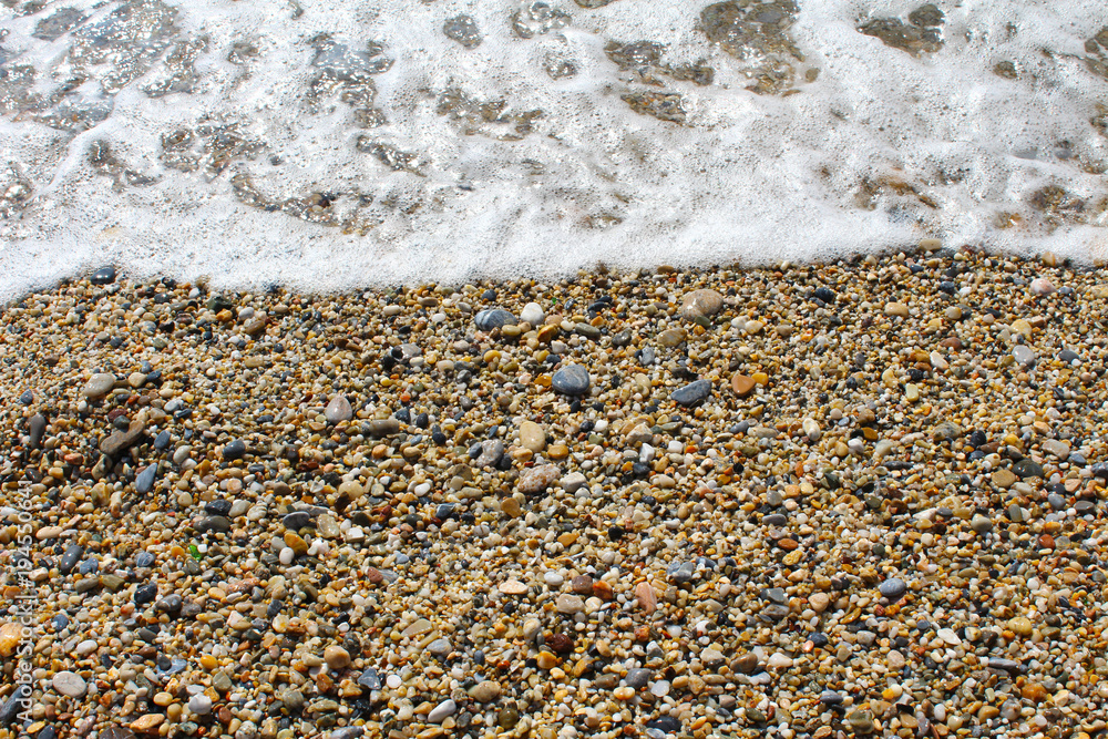 Pebble shore with sea foam of the wave Pebble shore with sea foam of the wave